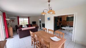 a dining room and living room with a table and chairs at Les Ptis Bregeons in Talmont
