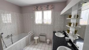 a bathroom with two sinks and a bath tub and a tubermott at Les Ptis Bregeons in Talmont