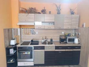a small kitchen with a stove and a sink at Апартамент Туида in Sliven