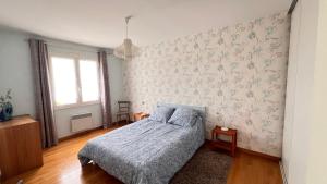 a bedroom with a bed with a blue comforter at Les Ptis Bregeons in Talmont