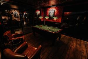 a billiard room with a pool table and chairs at Le Speakeazy in Petite Île