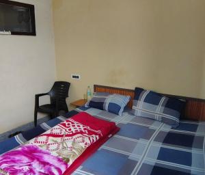 a bedroom with a bed with a red and blue comforter at Gate valley home stay in Dalhousie