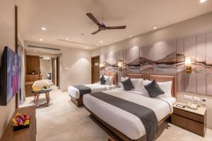 a hotel room with two beds and a tv at SkkyLight Lords Inn Nanded in Nānded