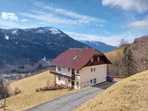 a house with a red roof on top of a hill at Tischnerhof Appartements in Bad Kleinkirchheim