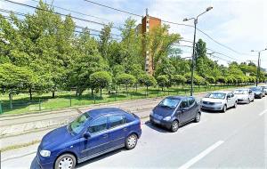 a row of cars parked on a street at The Kiss Apartment in Timişoara