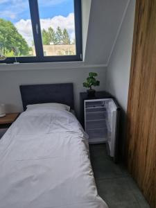 a bedroom with a bed and a window at Port Bobięcino in Bobięcino