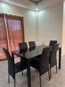 a black dining room table with black chairs at Jens Residence villa in Bamban +29 photos