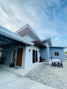 a blue and white house with a table and chairs at Jens Residence villa in Bamban