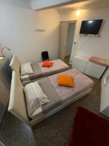 two beds in a room with a flat screen tv at Tramonto in Mele