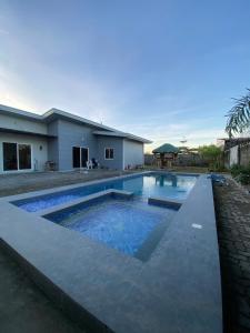 a swimming pool in front of a house at Jens Residence villa in Bamban
