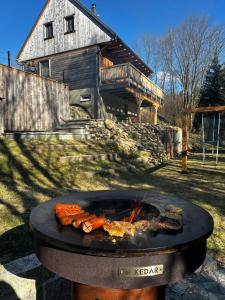 a grill with food on it in front of a house at Chalet Olešnice in Olešnice v Orlických horách