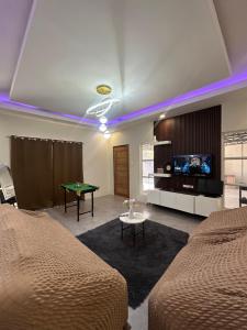 a bedroom with two beds and a tv and a table at Jens Residence villa in Bamban