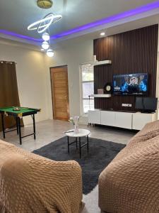 a living room with a pool table and a tv at Jens Residence villa in Bamban
