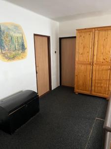 an empty room with a bed and wooden cabinets at Zlatá Stezka in Modrava