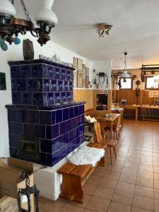 a room with a fireplace with blue tiles on the wall at Zlatá Stezka in Modrava