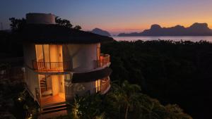 a building with a tower with a sunset in the background at Atalaya Resort El Nido in El Nido +44 photos