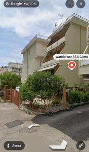 a building with a fence in front of it at Wanderlust Guesthouse in Gaeta