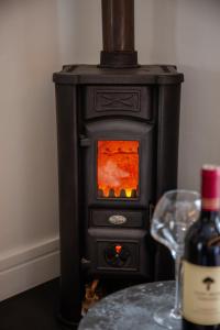 a black stove with a bottle of wine and a glass at Le Petit Manoir Boutique Hotel in Franschhoek