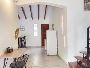 a kitchen with a white refrigerator and a table at Villa Serenity in Les Abymes
