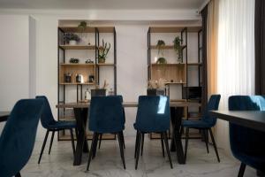 a dining room with a table and blue chairs at Hotel Paris & SPA in Chişinău