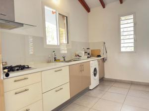 a kitchen with a sink and a washing machine at Villa Serenity in Les Abymes +18 photos