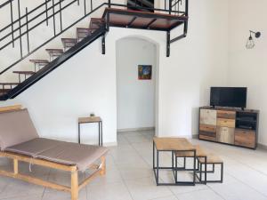 a living room with a couch and a tv and stairs at Villa Serenity in Les Abymes