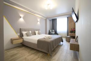 a hotel room with a bed and a chair at Hotel Paris & SPA in Chişinău