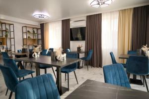 a dining room with tables and blue chairs at Hotel Paris & SPA in Chişinău
