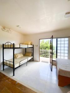 a bedroom with two bunk beds and a balcony at A & L Resort - Sea & Mountain View in Looc