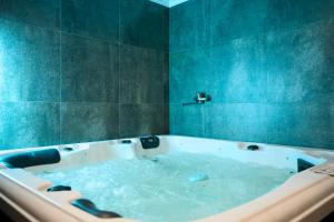 a bath tub filled with water in a bathroom at Hotel Paris & SPA in Chişinău +115 photos