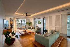 a living room with two couches and a television at Hemingways Watamu in Watamu