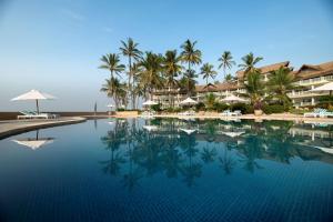 a pool at a resort with palm trees and umbrellas at Hemingways Watamu in Watamu