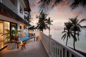 a balcony with a couch and a view of the ocean at Hemingways Watamu in Watamu