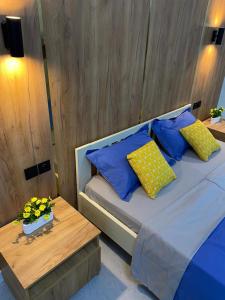 a bedroom with a bed with blue pillows and a table at AIDANA гостиница in Oral +13 photos