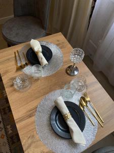 a wooden table with two black plates and napkins andoverty at AIDANA гостиница in Oral
