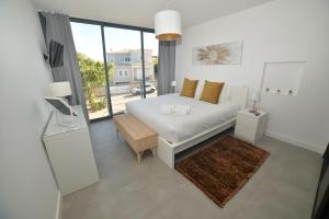 a white bedroom with a bed and a balcony at Villa Alvor in Alvor +86 photos