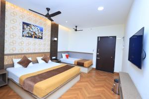 a bedroom with a bed and a tv in it at Thendral inn in Vellore