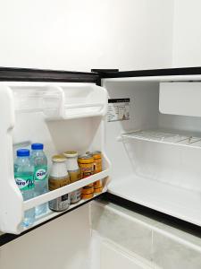 an open refrigerator filled with lots of food and drinks at A & L Resort - Sea & Mountain View in Looc