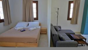 a small bedroom with a bed and a couch at Gefyra Studios Filoti Naxos in Filótion