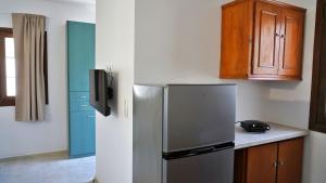 a kitchen with a refrigerator and wooden cabinets at Gefyra Studios Filoti Naxos in Filótion