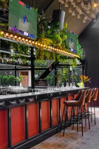 a bar with two chairs and a counter with plants at asar Upper House Morjim Beach by Orion Hotels in Morjim