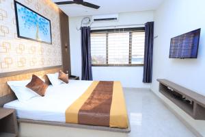 a bedroom with a bed and a large window at Thendral inn in Vellore