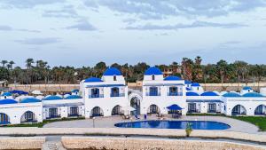 a large white building with blue domes and a pool at New Panorama Resort in Fayoum