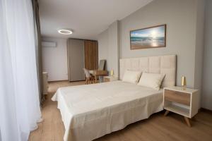 a bedroom with a large white bed and a table at SoleMare Luxury 2 Bedroom Apartment in Aheloy +16 photos