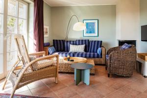 a living room with a couch and chairs and a table at Haus Arrewind in Ahrenshoop