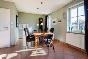 a dining room with a wooden table and chairs at Haus Arrewind in Ahrenshoop +16 photos