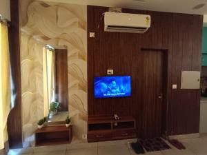 a living room with a television and a mirror at Darshana Studios# Couple Friendly in Noida