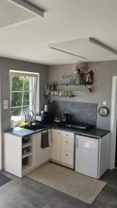 a kitchen with white cabinets and a black counter top at ''Ābeļdārza māja'' in Āboliņi +20 photos