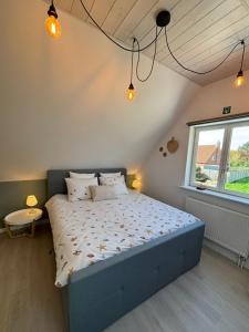 a bedroom with a large bed in a room with a window at De Strandloper B&B Oostduinkerke in Koksijde