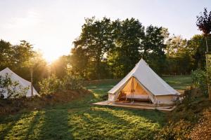 two tents in a field with the sun setting at Le Domaine de Bra in Bra